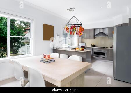 Cucina interno con tavolo, lavabo, armadi grande finestra e pavimento in piastrelle in casa di lusso. Foto Stock