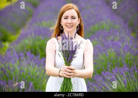 Donna cammina con bouquet in lavanda campo, repubblica Ceca Foto Stock