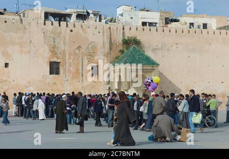 Nel pomeriggio a Meknes, Marocco, gente marocchina sulla piazza vicino alle mura della città Foto Stock