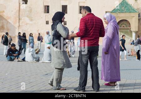 Nel pomeriggio a Meknes, Marocco, la gente marocchina sulla piazza vicino alle mura della città Foto Stock