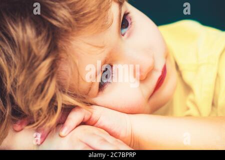 Ragazzo seduto alla scrivania sullo sfondo dell'aula. Foto Stock