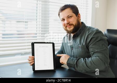 Uomo che ottiene il visto e la domanda di lettura su tablet. Foto Stock