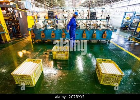 Johannesburg, Sudafrica - 16 ottobre 2012: Operaio africano di fabbrica su un telaio della linea di assemblaggio della trama del copwinder Foto Stock