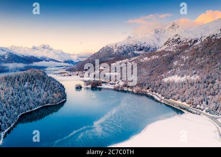 Boschi innevati sulla riva di Lej da Champfer con Silvaplana e Piz da la Margna sullo sfondo, Graubunden, Engadina, Svizzera Foto Stock