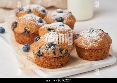 Muffin al mirtillo, vista laterale, primo piano. Cupcake con frutti di bosco su tavolo di cemento bianco Foto Stock
