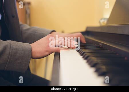 Primo piano di un musicista che suona al pianoforte con le mani in primo piano Foto Stock