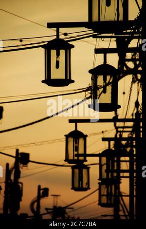 Ripresa verticale di silhouette di lanterne metalliche durante il tramonto a Kawagoe, Giappone Foto Stock