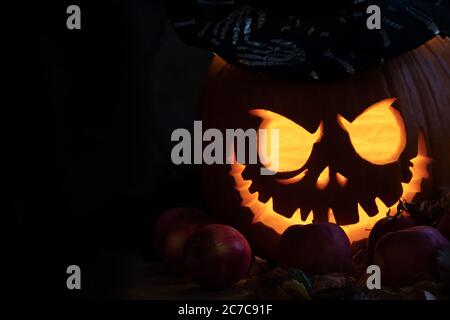 Halloween testa jack lanterna di zucca con occhi luminosi e bocca con candele su sfondo nero con copyspace Foto Stock