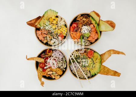 Colpo d'asta di quattro ciotole piene di cibo con bastoncini su uno di loro Foto Stock