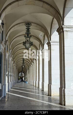 Colonne lungo la piazza commerciale 'Praca de Commercio' di Lisbona all'alba Foto Stock