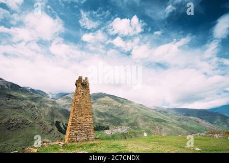 Sioni, Georgia. Antico campanile in pietra antica sullo sfondo della montagna nel villaggio di Sioni, distretto di Kazbegi, regione di Mtskheta-Mtianeti, Georgia. Molla o. Foto Stock