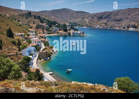 Foto ad alto angolo di un bellissimo mare circondato da alte montagne rocciose e edifici a Symi, Grecia Foto Stock