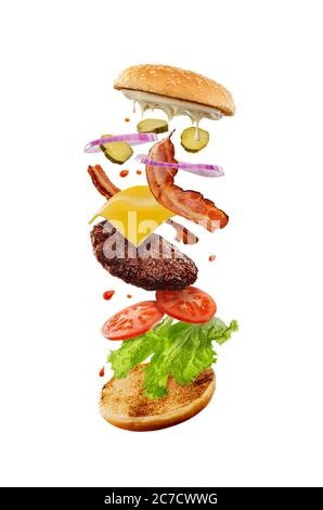 Hamburger appetitoso con ingredienti volanti. Fast food Foto Stock