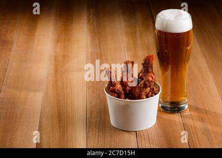 Servivano bricietti di birra e pollo su un tavolo di legno Foto Stock