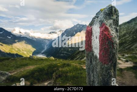 Segnavia sulle montagne. Segno dipinto in rosso e bianco per turisti, escursionisti e escursionisti. Aiuta a navigare escursionisti durante le escursioni. Trekking Foto Stock