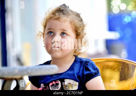 Cute bambina beve succo d'arancia con cannuccia bevente. luglio 12, 2020 resen, macedonia Foto Stock