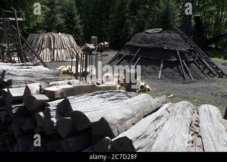 Hasselfelde, Germania. 21 Maggio 2020. Un tradizionale palo di terra (l), come è costruito per la produzione di carbone, è pronto per essere illuminato nelle opere di carbone Harz a Hasselfelde. Nella miniera di carbone di Harz, i visitatori sono esposti in modo vivace l'antico artigianato. La miniera di carbone di Harz produce annualmente oltre 50 tonnellate di carbone. È una delle ultime piante di carbone che ancora operano il vecchio mestiere in Germania. Credit: Matrhias Bein/dpa-Zentralbild/ZB/dpa/Alamy Live News Foto Stock