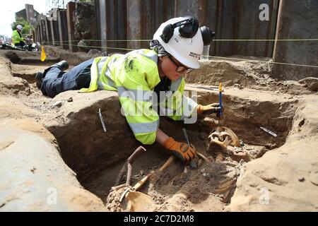 L'archeologo Clare McCabe dai tram a Newhaven progetto di scavo di resti umani, che potrebbero risalire fino al 1300, dalle tombe della Chiesa Parrocchiale di Leith Sud il cui cimitero medievale si estende sotto la superficie stradale di Constitution Street, Leith. Foto Stock