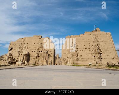 l'imponente facciata (pilone) del tempio di karnak con statue e un grande muro Foto Stock