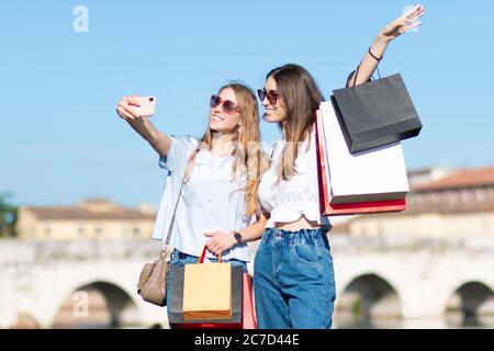 due giovani turisti goda shopping e selfie - fidanzata prende selfie dopo lo shopping Foto Stock