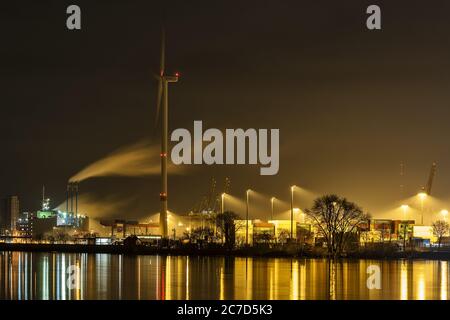 Getto orizzontale di numerosi sprinkler ad acqua sul riva vicino agli edifici di notte Foto Stock