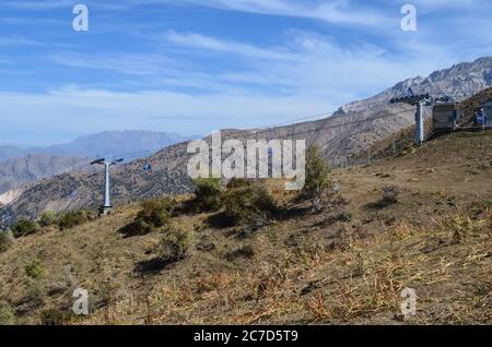 Funivia nelle montagne dell'Uzbekistan. Arrampicarsi sulla montagna. Beldersay. In una giornata estiva soleggiato. Foto Stock