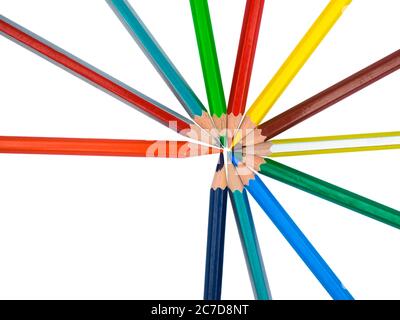 Alcuni pastelli a matita di legno colorati diversi messi su una carta bianca in un cerchio rotondo Foto Stock