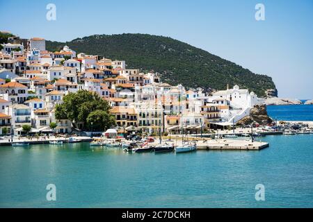 La storica città sull'isola di Skopelos vista dalla barca quando si entra nel porto in luce estiva. Foto Stock