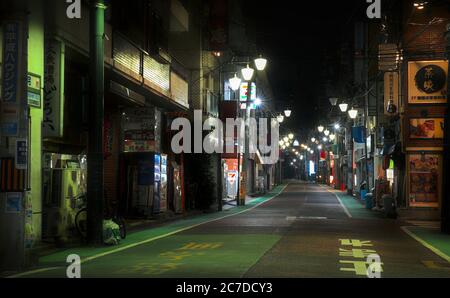 Guardando giù per una vuota Akebonobashi Street a tarda notte, una zona di negozi e ristoranti solitamente trafficata nella parte orientale di Shinjuku, Tokyo Foto Stock