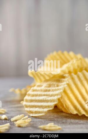 Un mucchio di patatine croccanti si trova sul tavolo. Cibo spazzatura, fast food, malsano. Foto Stock