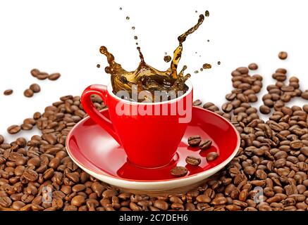 il caffè spruzzava in una tazza rossa sui chicchi di caffè Foto Stock