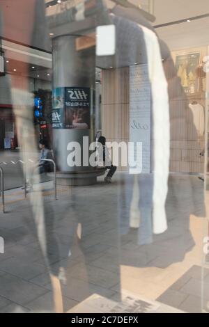 MATSUYAMA, GIAPPONE - 21 settembre 2019: Una vista di persone sedute su un sedile a colonna rotonda all'interno di un centro commerciale attraverso una finestra di vetro Foto Stock