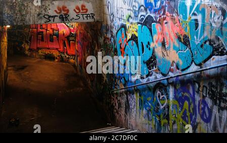 Abbandonato passaggio sotterraneo con vecchi graffiti e vecchie cartoline sopra le pareti Foto Stock