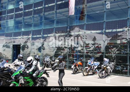 Franz-Josefs-Höhe, Austria: Motociclisti sulla famosa terrazza panoramica (altezza 2369 m) di fronte alla facciata in vetro del parcheggio. Europa. Foto Stock