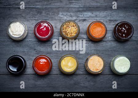 Ampia collezione di salse e spalmabili in piccoli vasi come salsa di soia mayo ketchup senape e molto altro Foto Stock