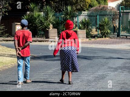 Alberton, Sudafrica - giovane anziano non identificato che cammina in una strada pubblica durante il blocco per l'immagine del covid-19 in formato orizzontale Foto Stock
