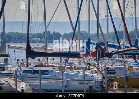 Steinhude, Germania, 29 maggio 2020: Molte piccole barche a vela con alberi senza ancora di rigging in un punto di atterraggio nel porto del grande lago Foto Stock