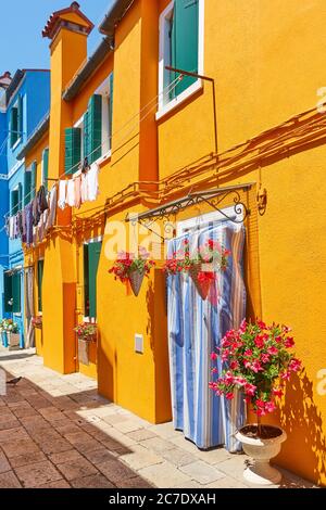 Strada con vecchie case dai colori vivaci nell'isola di Burano a Venezia. Paesaggio urbano italiano Foto Stock