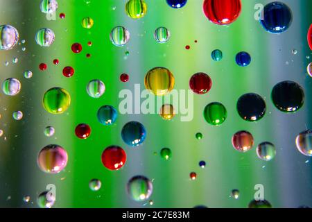 Gocce d'acqua colorate astratte su sfondo verde Foto Stock