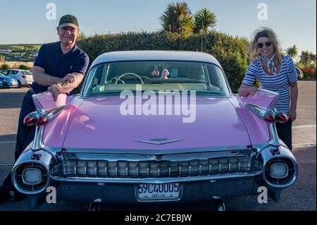 Inchydoney, West Cork, Irlanda. 16 luglio 2020. Una Cadillac rosa 1959 è stato un visitatore a sorpresa a Inchydoney Beach in West Cork oggi. Nella foto con l'auto sono il proprietario di un veicolo Olwen Venn e suo marito Douglas, entrambi di Blarney. Credit: Notizie dal vivo di AG/Alamy Foto Stock