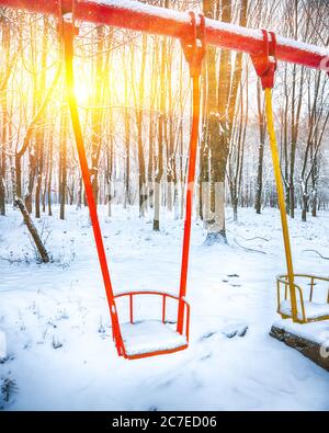 Oscillazione vuota in inverno con neve. I bambini oscillano sotto uno spesso strato di neve Foto Stock