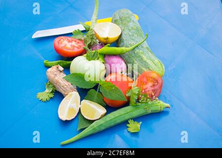 Piatto di verdure fresche biologiche per sfondo, verdure diverse per mangiare frutta e verdura sana, colorata su sfondo blu Foto Stock