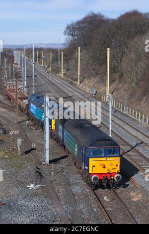 2 servizi ferroviari diretti classe 57 locomotive diesel 57007 + 57003 che lasciano il cantiere Carlisle Kingmoor con un breve treno merci Foto Stock