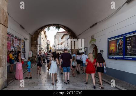 I turisti entrano in uno dei vecchi ingressi a muro della città vecchia di Zara da Ulica Nova Vrata a Ulica Jurja Barakovića Foto Stock