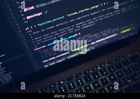 Primo piano dello schermo di un laptop con righe di codice su sfondo nero Foto Stock