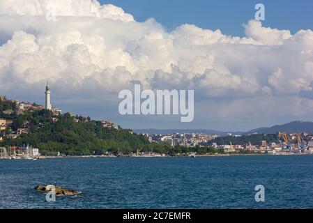 Skyline di Trieste, Italia, e la Vittoria Light vista dal lungomare del quartiere Barcola in una giornata estiva Foto Stock