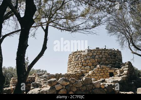 Bellissimo scatto di un'antica rovina vicino alberi con un cielo blu sullo sfondo durante il giorno Foto Stock