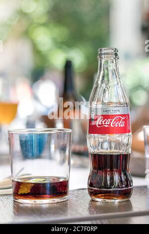 Una bottiglia di vetro di Coca Cola leggero gusto su un tavolo all'aperto. Foto Stock