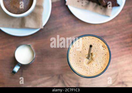 Vista dall'alto di un caffè freddo greco, freddo - caffè espresso in forma collocato su un tavolo di legno all'aperto Foto Stock