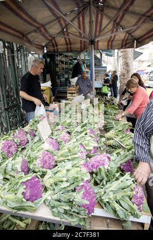 CATANIA, ITALY - Oct 15, 2016: Stalla vendita verdure con cavolfiori colorati, scelta dei prodotti da parte del cliente. Mercato, Catania, Sicilia, Italia Foto Stock